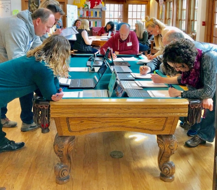 Candid moment around the pool table during Black Belt feedback